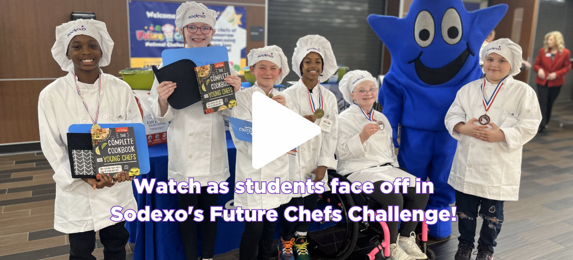 Photo shows six elementary students dressed as judges holding up prizes and awards with play arrow over them. Clicking the image leads you to a YouTube video about Sodexo's Future Chefs Challenge. The